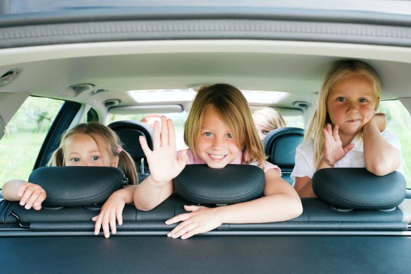 three daughters in the car with their parents