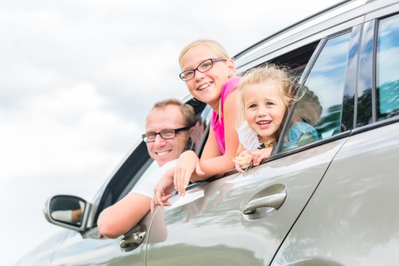 dad and daughters in car ready for vacation