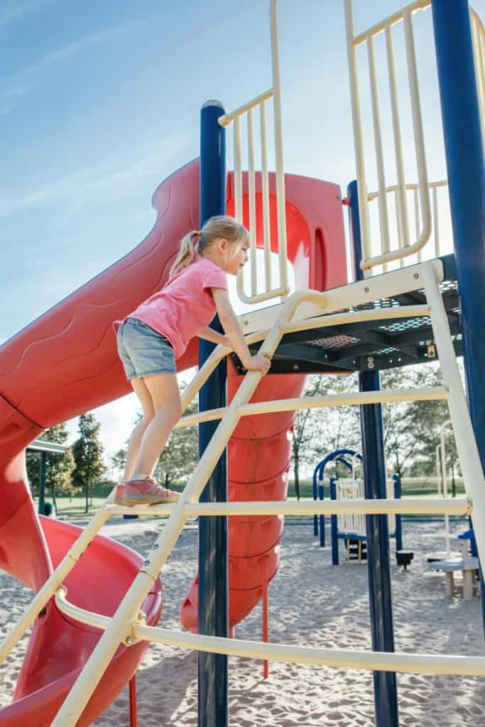 girl climbing on playground equipment
