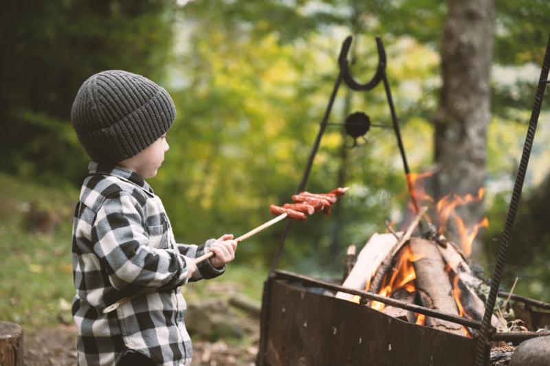 boy cooking over a campfire