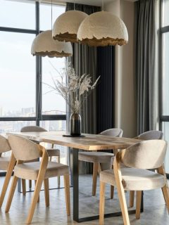 modern dining room with three hanging lights over the dining table and chairs