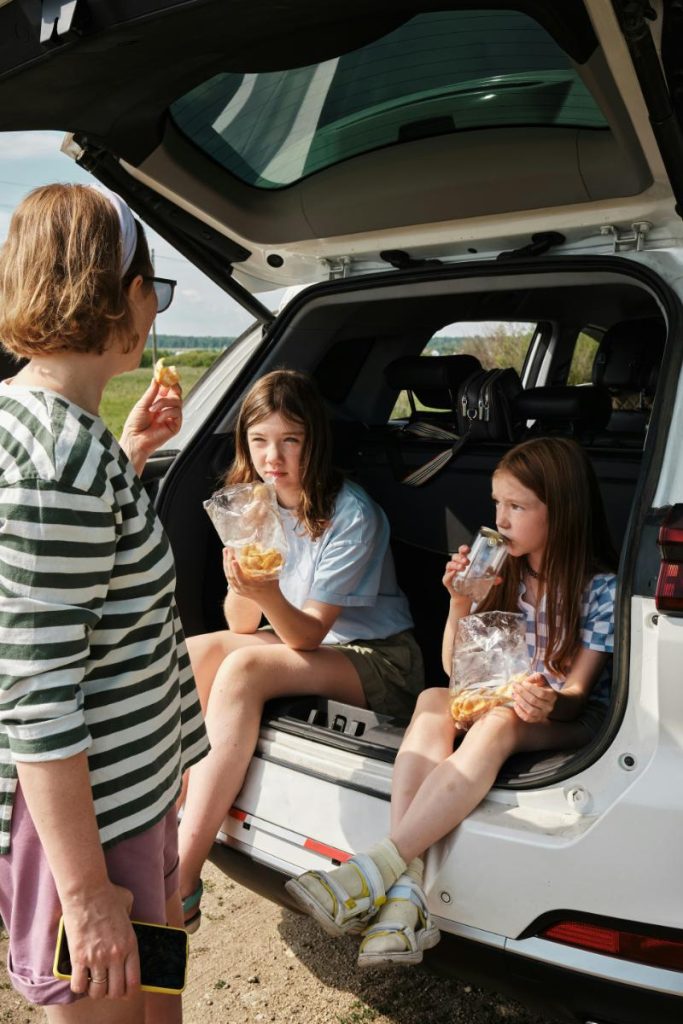 mom and daughters having a snack during a road trip