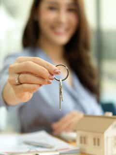 woman with house key with focus on hand and key