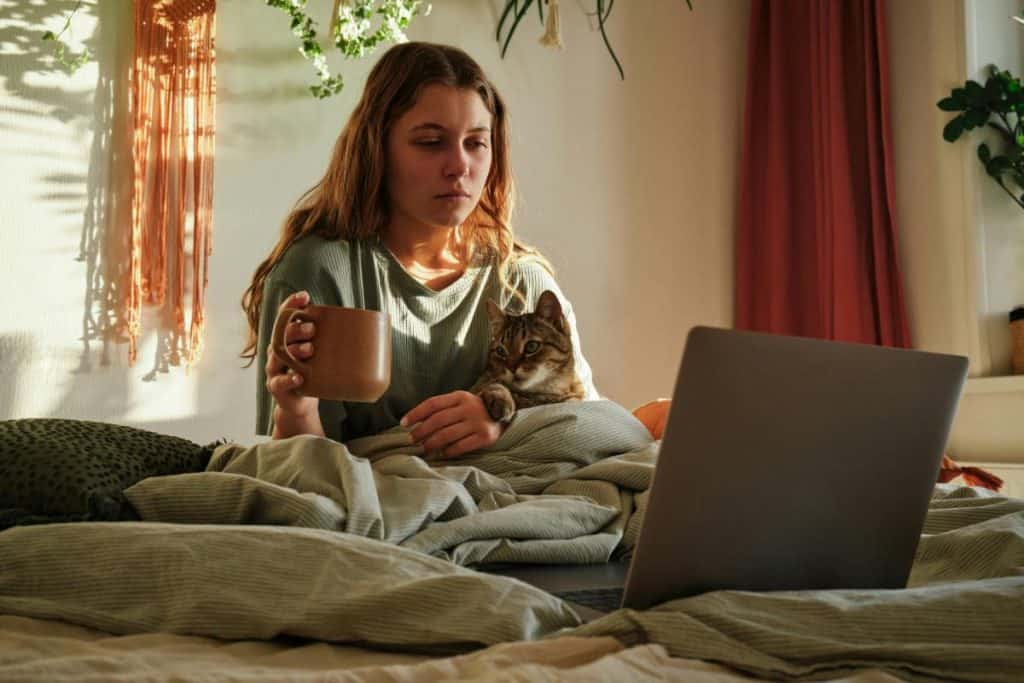 woman in bed with laptop and coffee