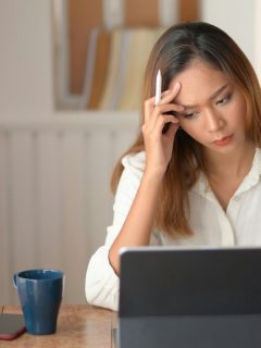 woman looking frustrated at tablet