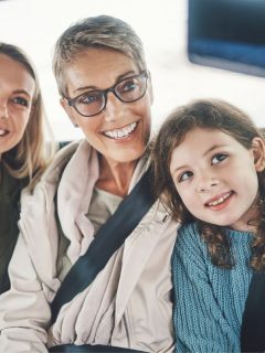 granddaughter, mother, and grandmother taking selfie together in car