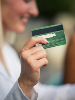 blonde woman holding up credit card