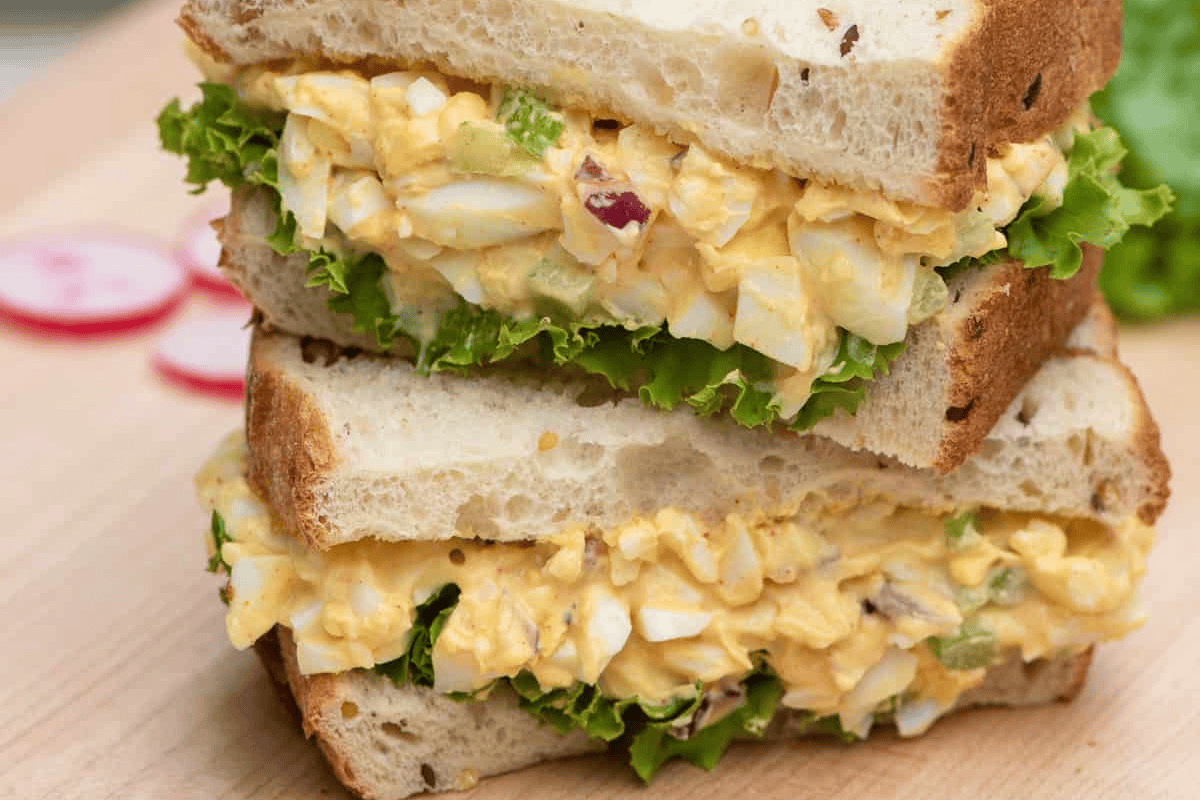 egg salad sandwiches on wood cutting board