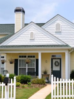 cute suburban house with white picket fence in front