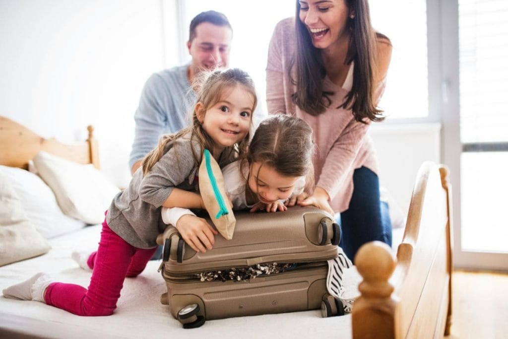 parents and daughters packing a suitcase