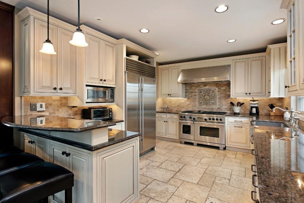 upscale kitchen with white cabinets and brick backsplash