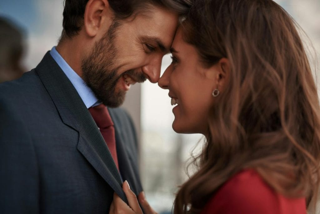 smiling man and woman face to face - man's tie matches woman's dress