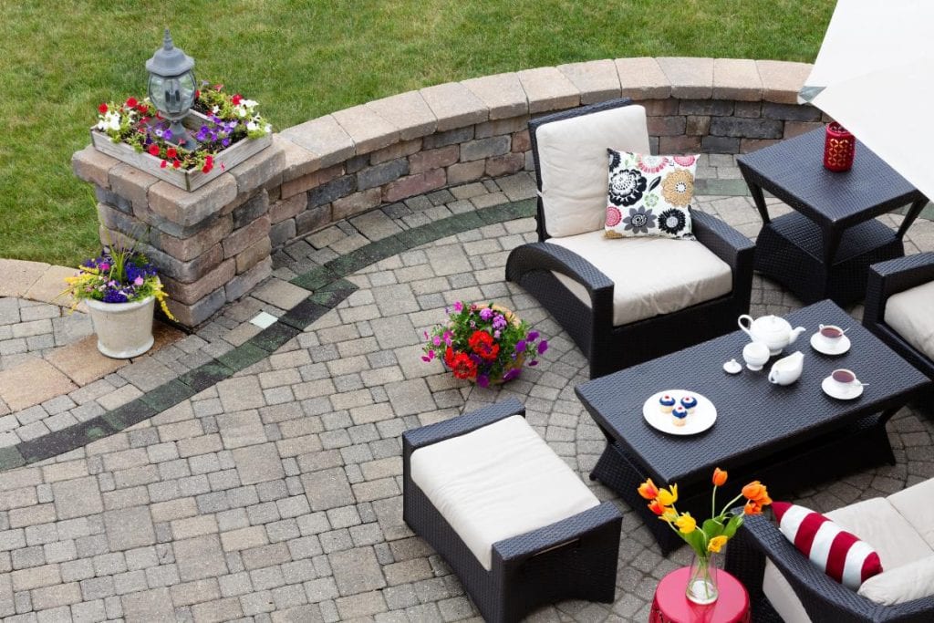 outdoor seating area with flowers and brick patio and wall