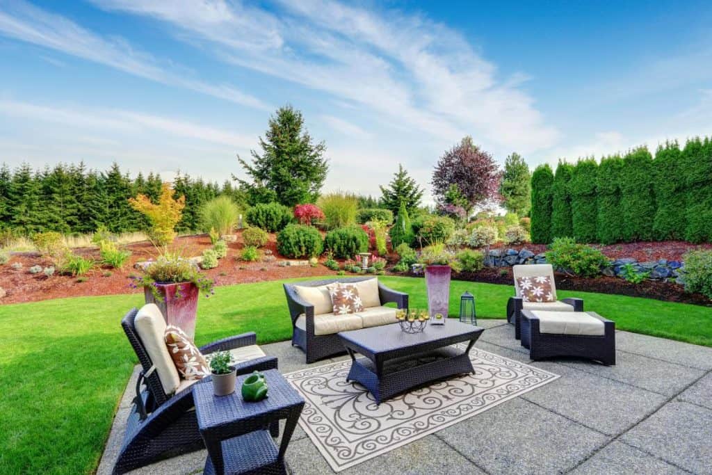 gorgeous backyard with patio, comfy seating, and pretty landscaping
