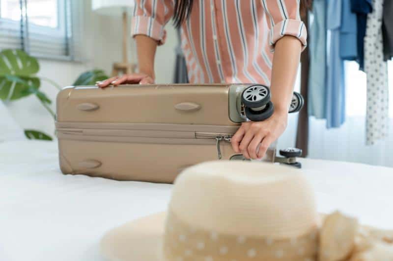 woman zipping a suitcase