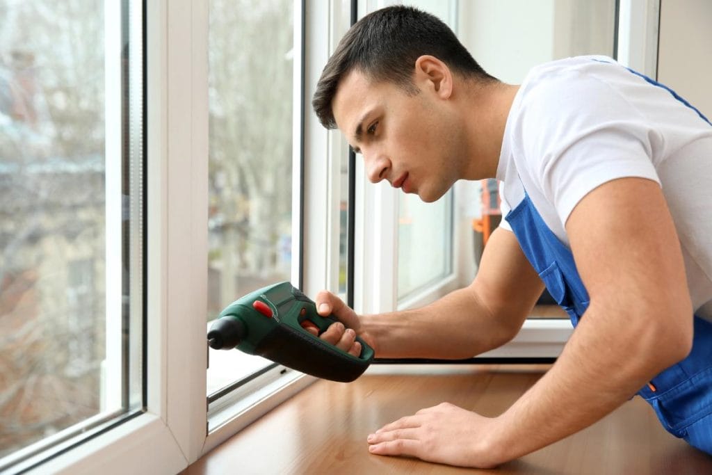 man using a drill to install a new window