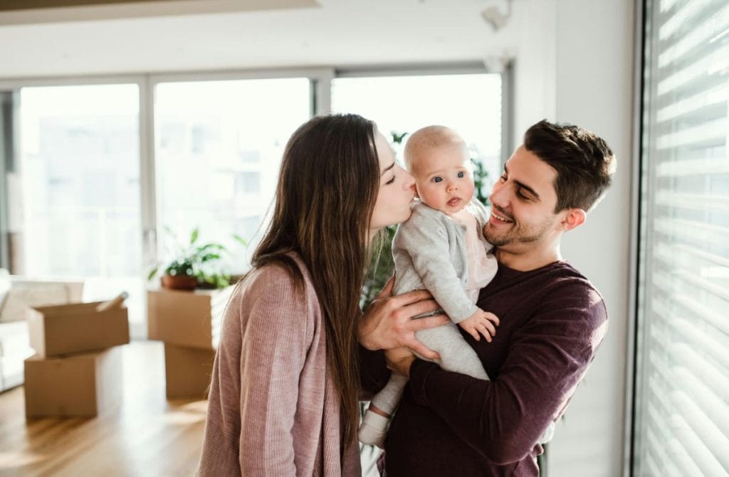 happy couple with baby in new home