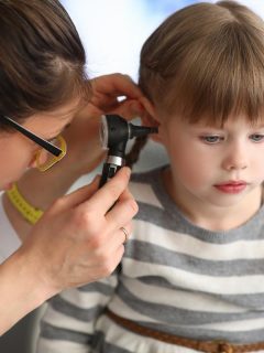 female doctor examining little girl's ear