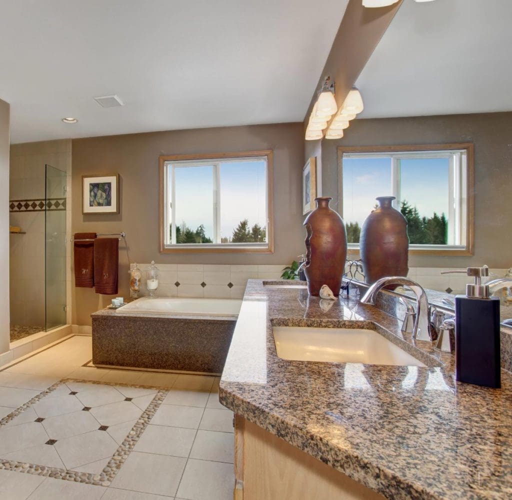 a traditional bathroom with granite counters and a big tub