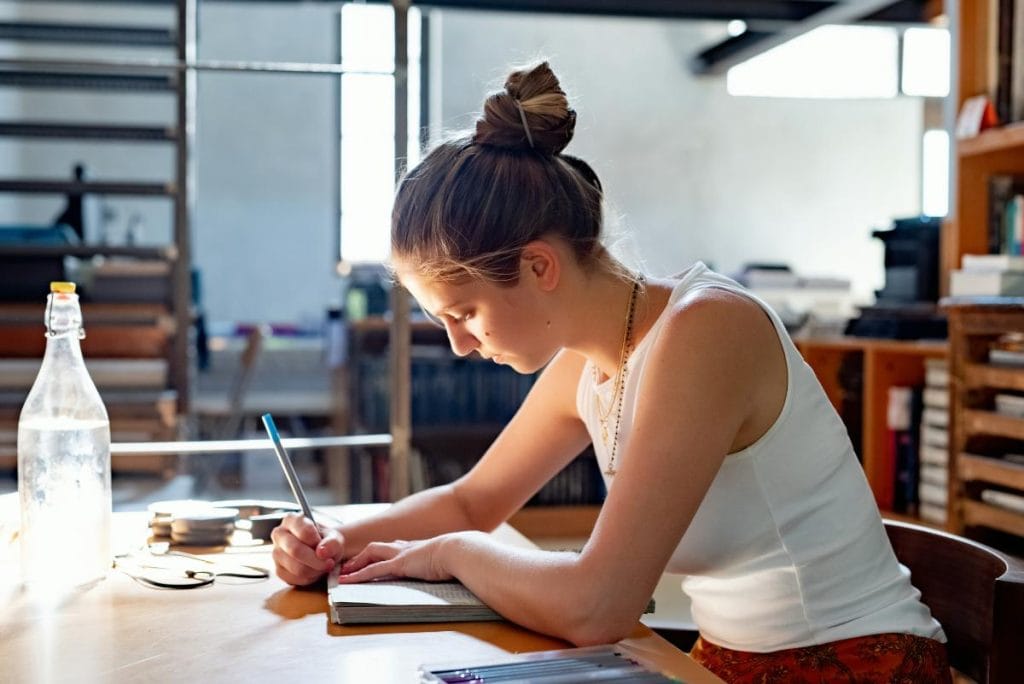 woman studying and writing in a notebook