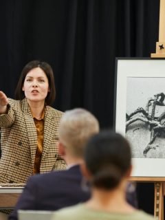 woman holding auction for a photograph or painting