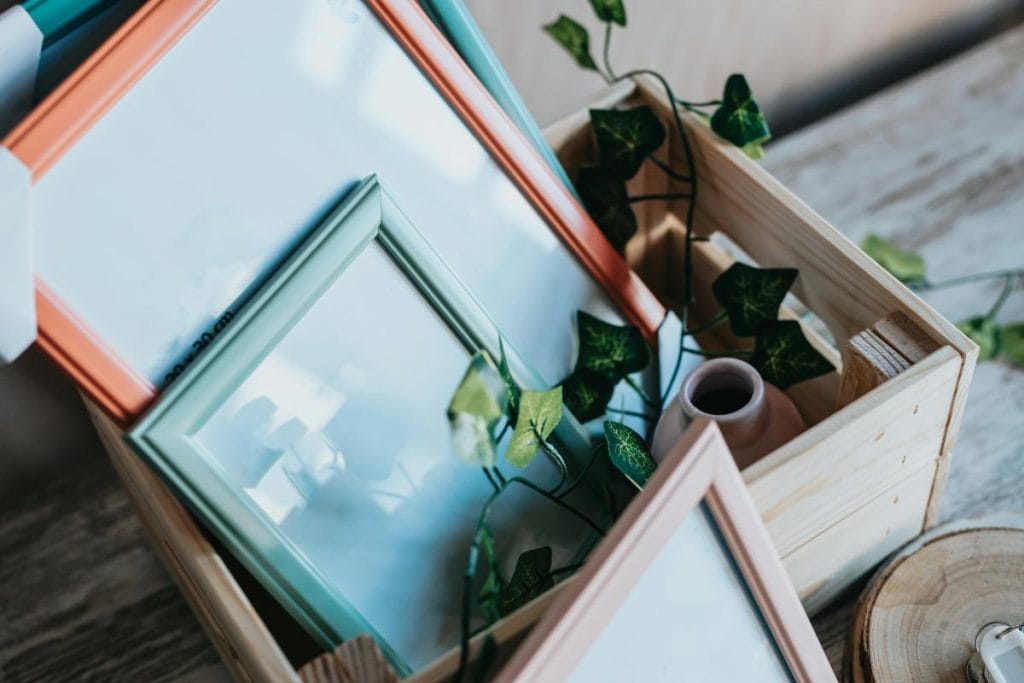 frames and vase in a wooden crate