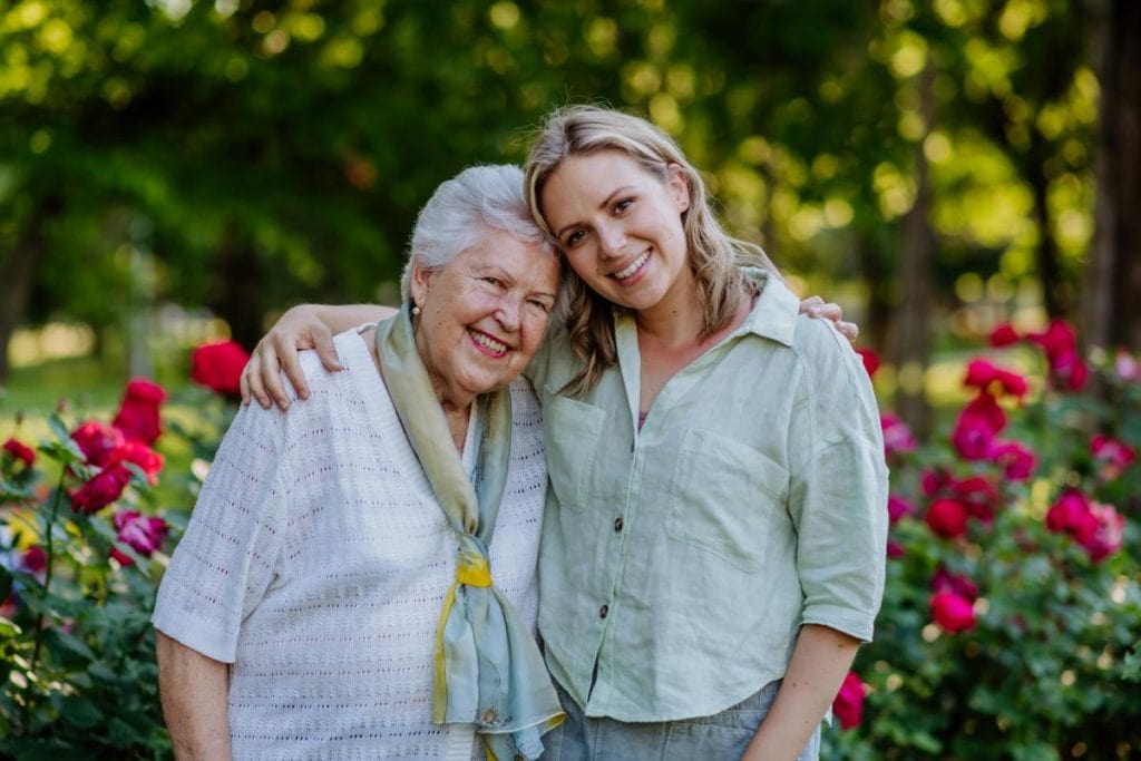 grandmother and adult granddaughter with arms around each other