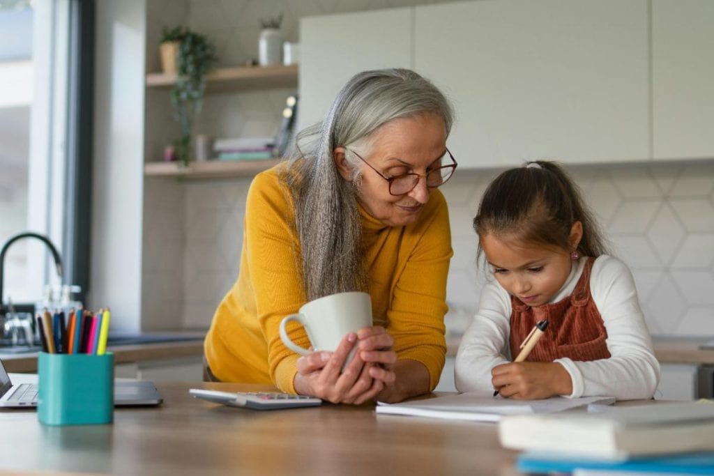 grandmother helping granddaughter with homework