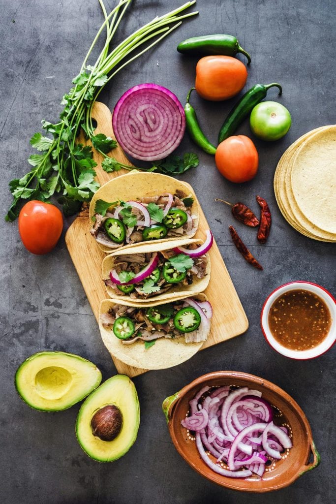 Mexican street tacos surrounded by fresh ingredients