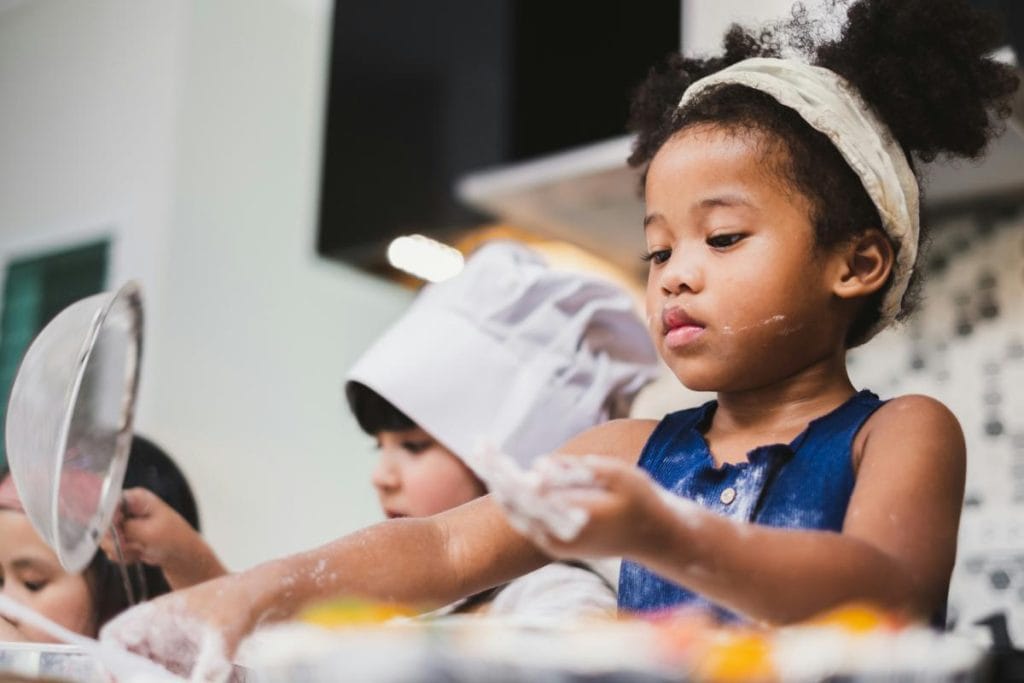 kids playing with flour and baking in a kitchen