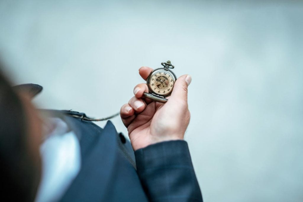 man holding old pocket watch