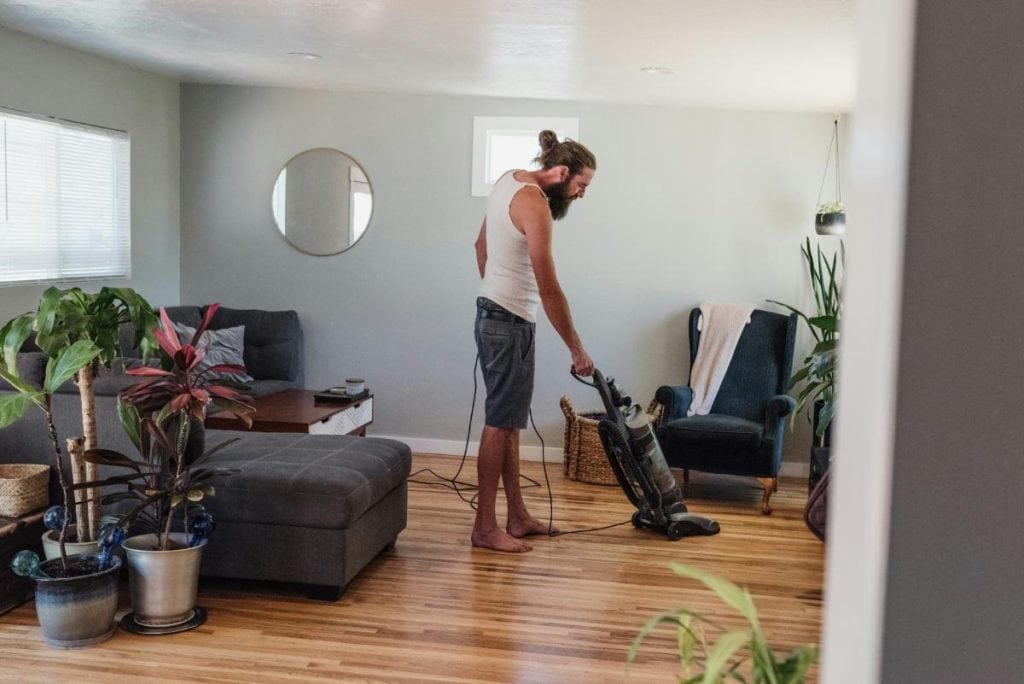 man vacuuming hardwood floor