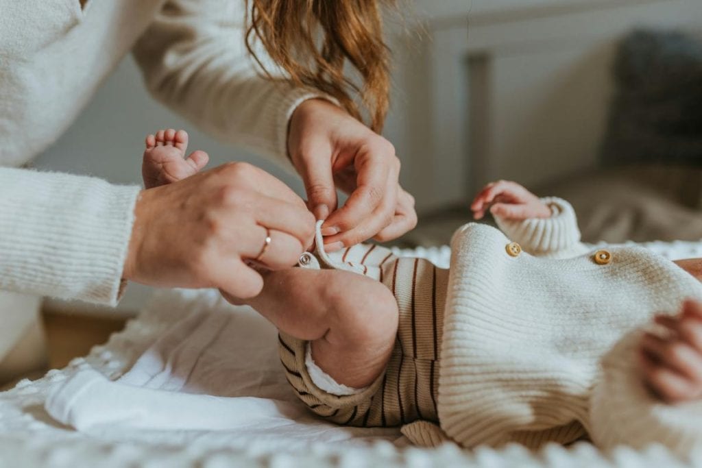 mother changing a baby