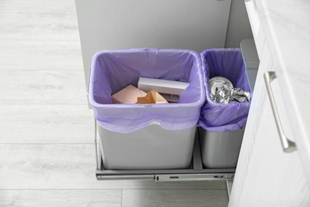 trash can and recycling can pulled out from cabinet