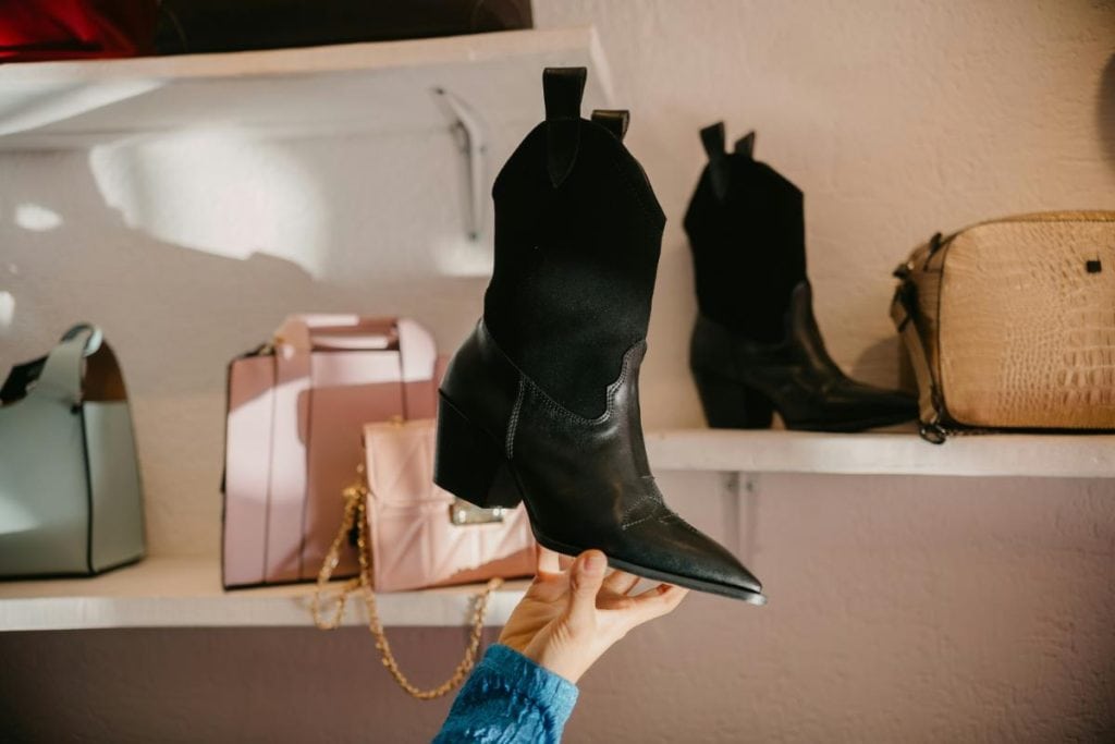 woman holding up black boots