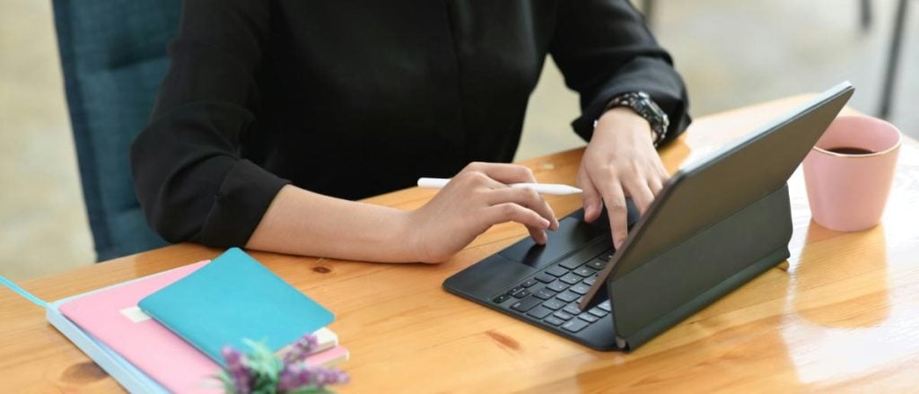 woman using tablet with a keyboard and pencil