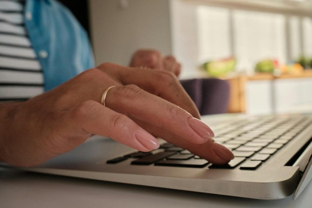 woman's hand on laptop keyboard