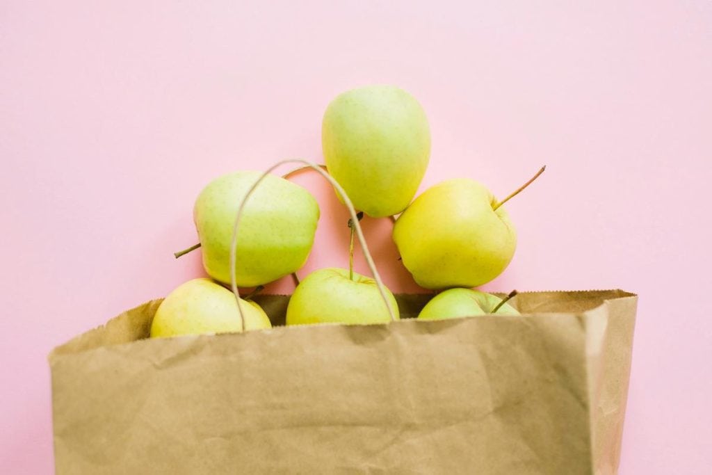 apples spilling out of a paper bag