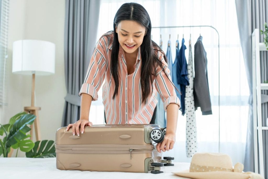 asian woman packing suitcase