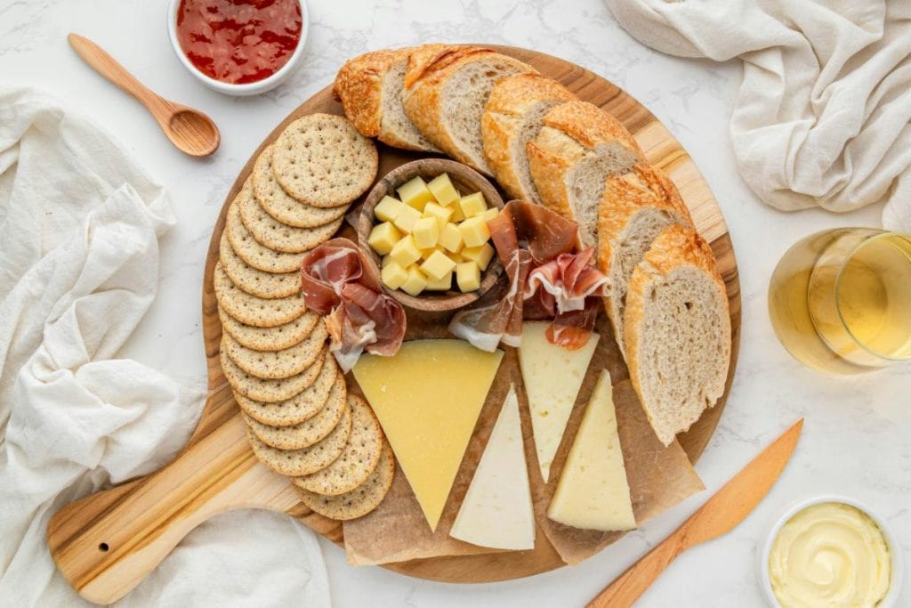 crackers and cheeses on serving board