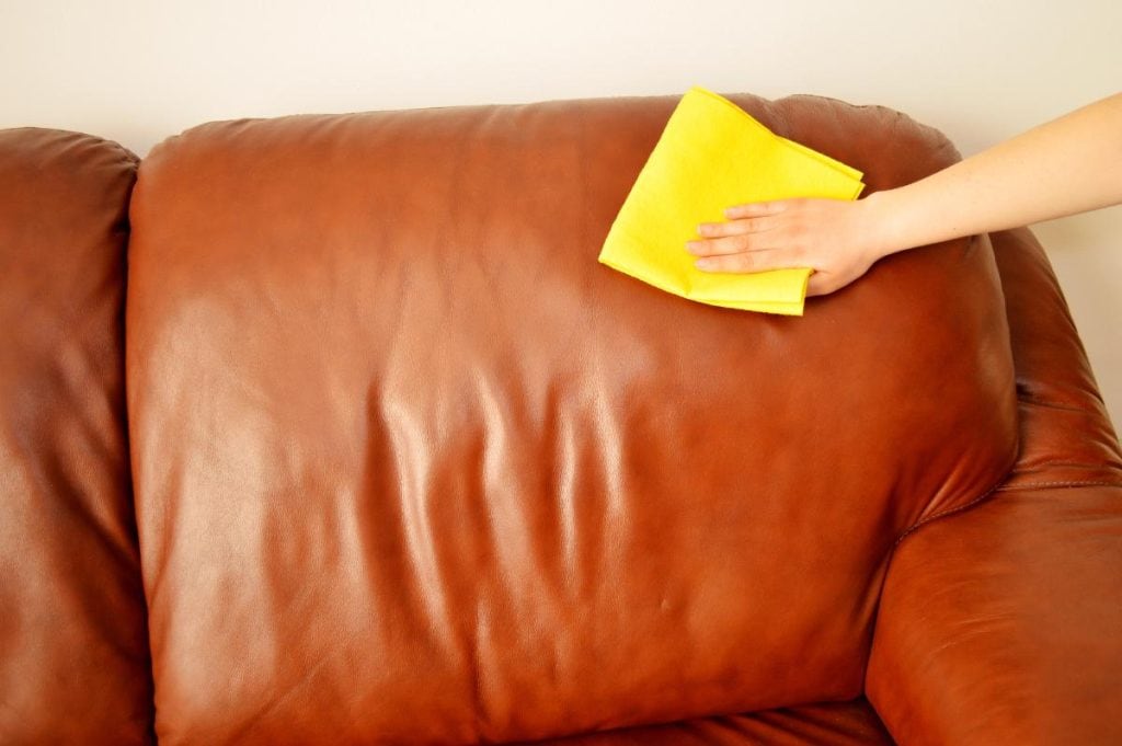 cleaning leather sofa with yellow cloth