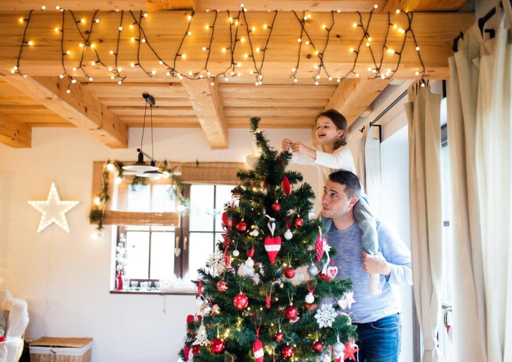 dad and daughter decorating a christmas tree