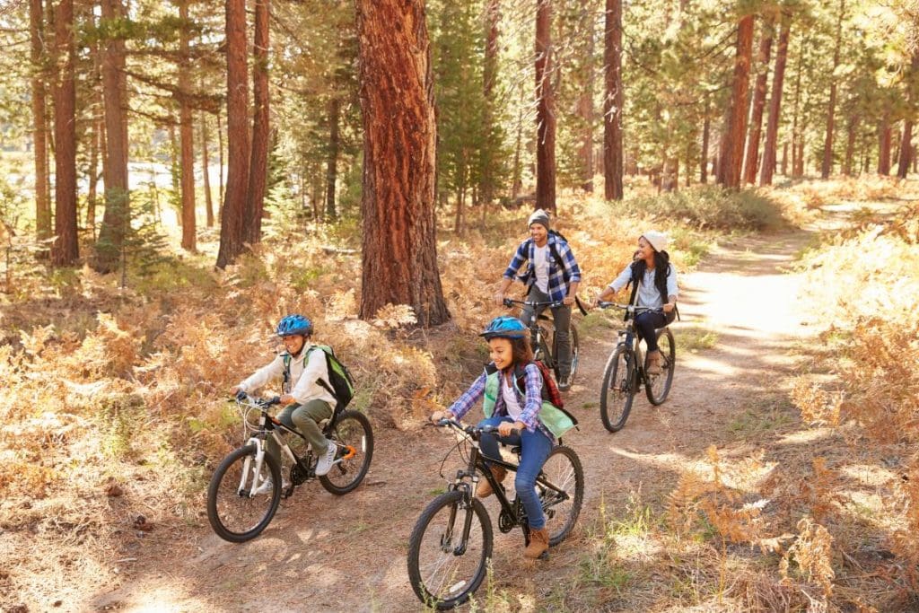 family riding bikes through forest