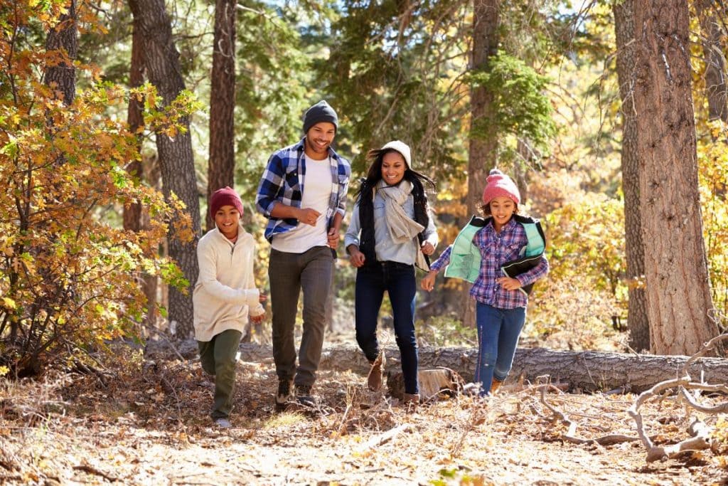 family walking through woods in the fall