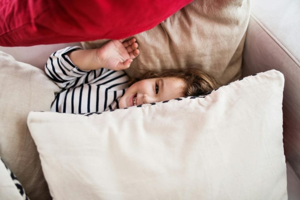 girl on couch covered with throw pillows