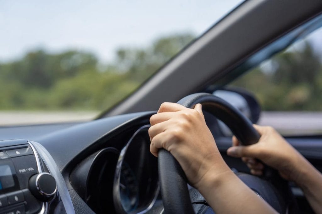 hands on car steering wheel