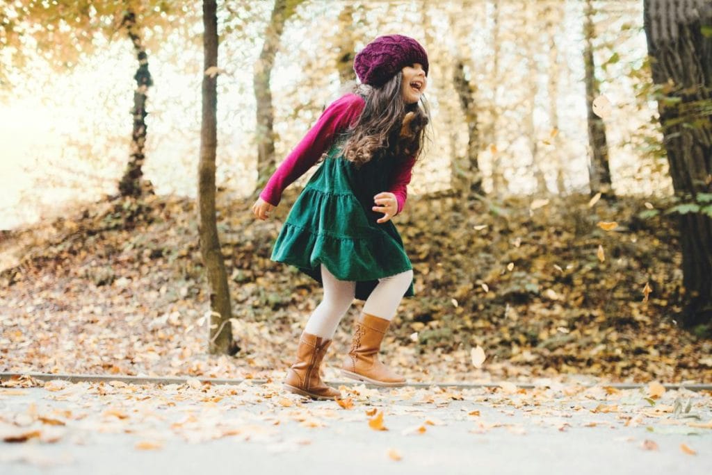 happy girl running in autumn forest