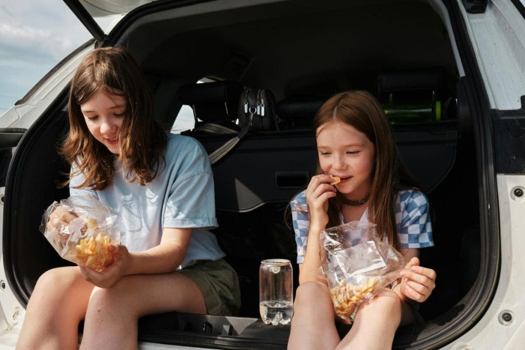 kids having a snack in back of suv