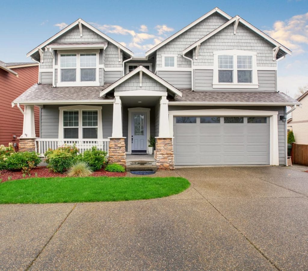 a large gray suburban house with view from the driveway