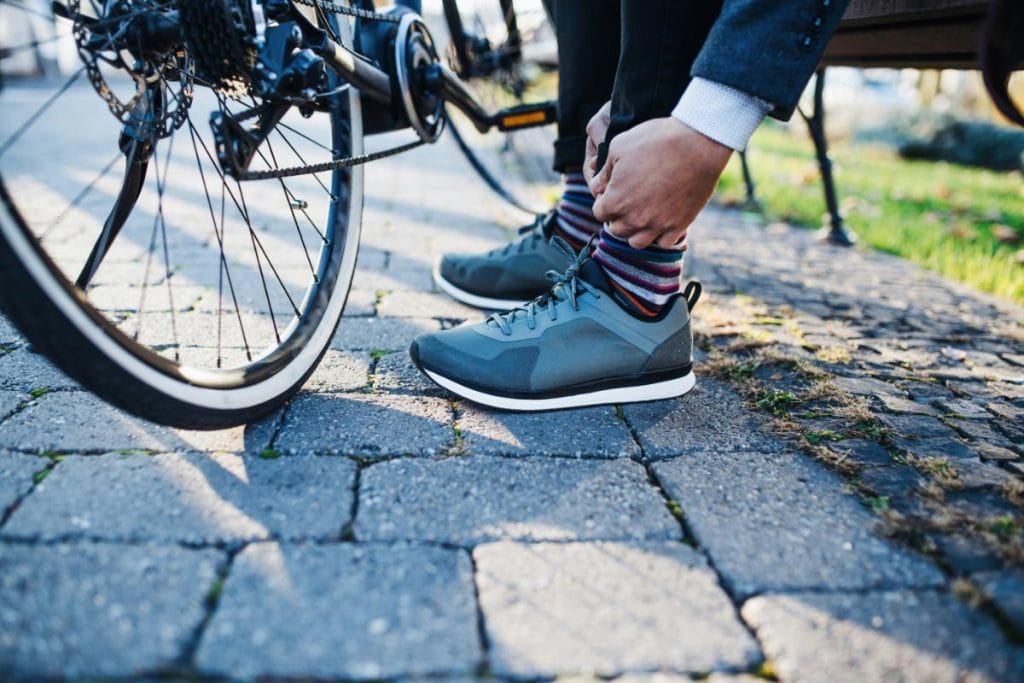 man with bike tying shoes